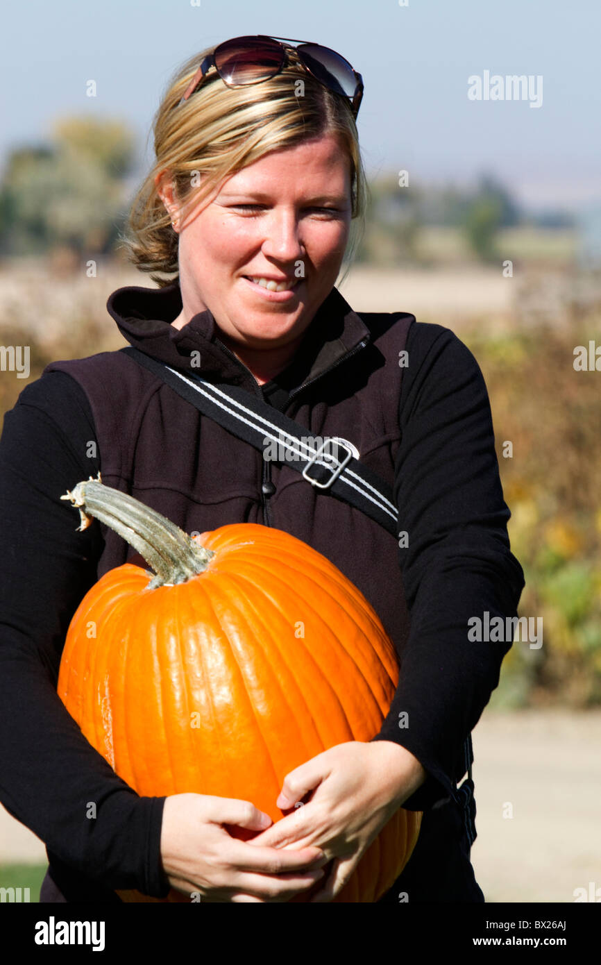Frau Wahl einen Kürbis auf einem Kürbisfeld in Fruitland, Idaho, USA. HERR Stockfoto