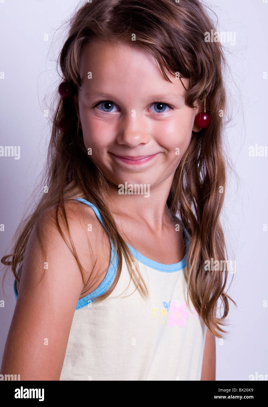 Ein süßes kleines Mädchen essen frisches Obst. Das Kind ist auf einem weißen Hintergrund Stockfoto