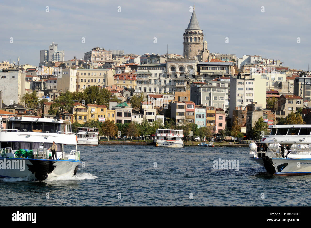 Turyol Sightseeing-Kreuzfahrt Touristenbooten das Goldene Horn, Istanbul, Türkei. Galata-Turm im Hintergrund Stockfoto