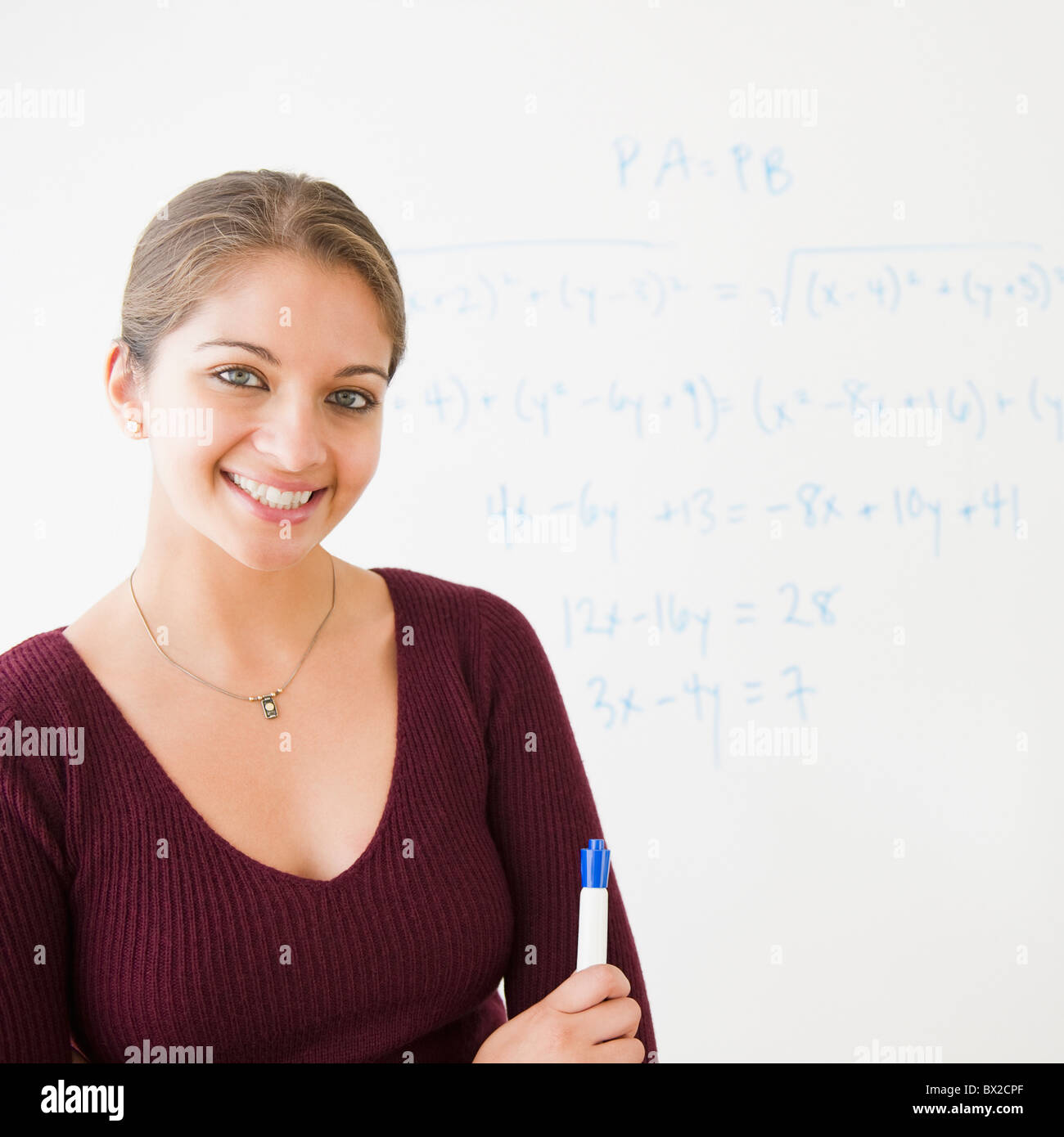 Lächelnde indischer Student neben Whiteboard im Klassenzimmer Stockfoto