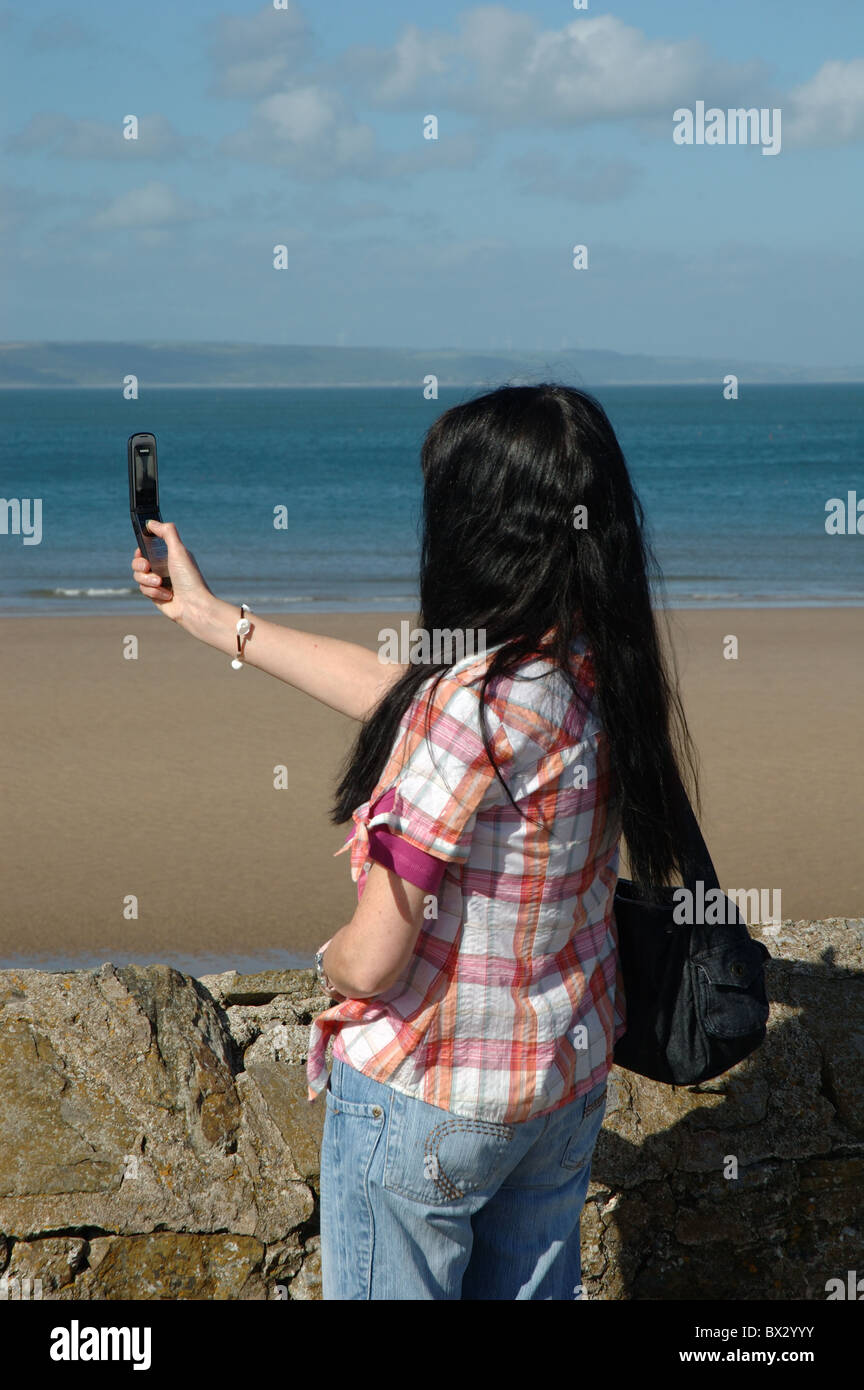 Frau nehmen Foto mit Handy, Tenby, Wales, UK Stockfoto