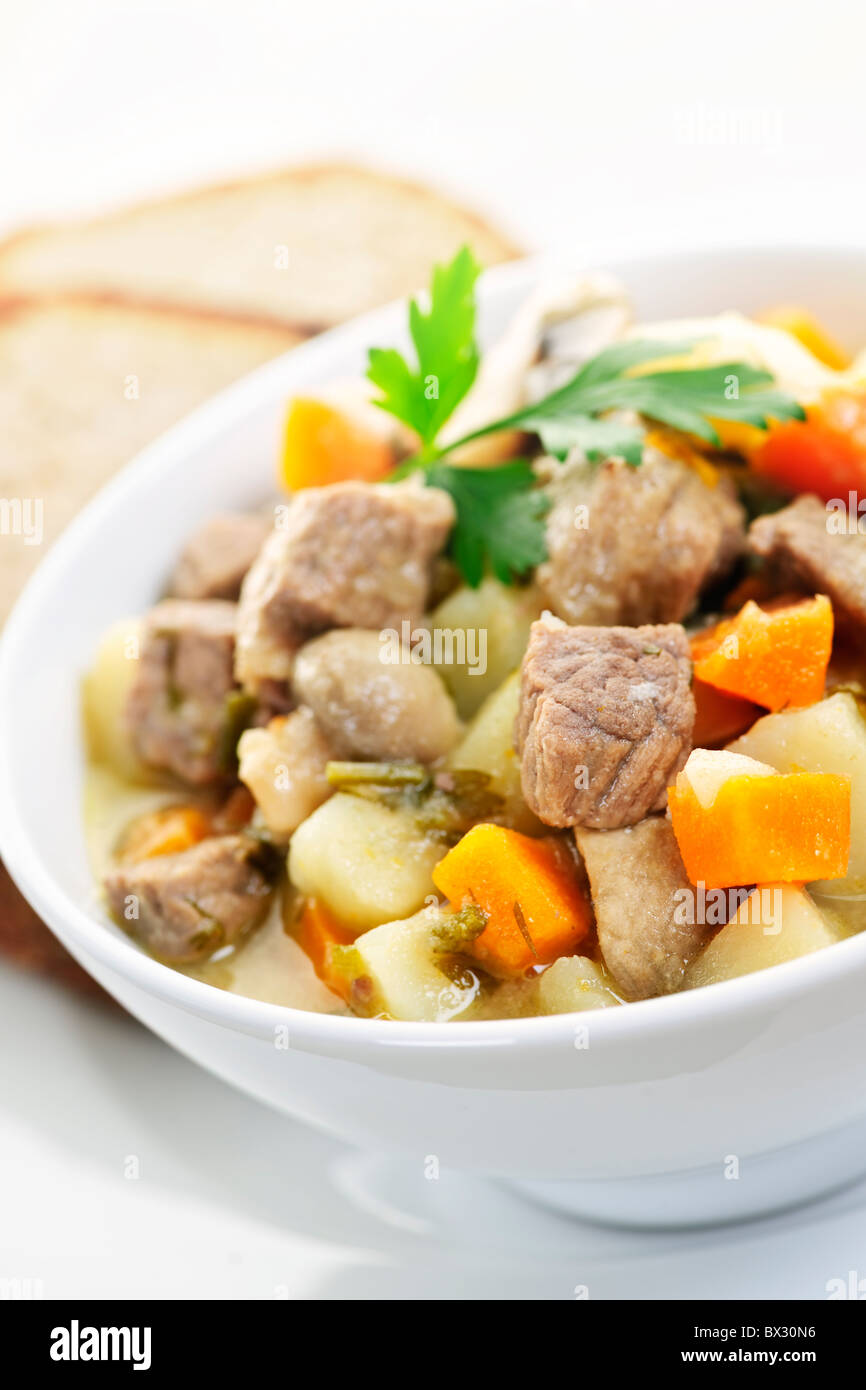 Schüssel mit herzhaften Rindfleisch-Eintopf mit Gemüse serviert mit Roggenbrot Stockfoto