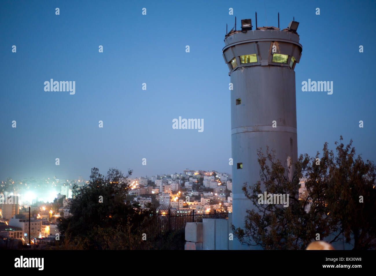 Ein israelische militärische Turm steigt in den Nachthimmel über der palästinensischen Stadt Hebron. Stockfoto