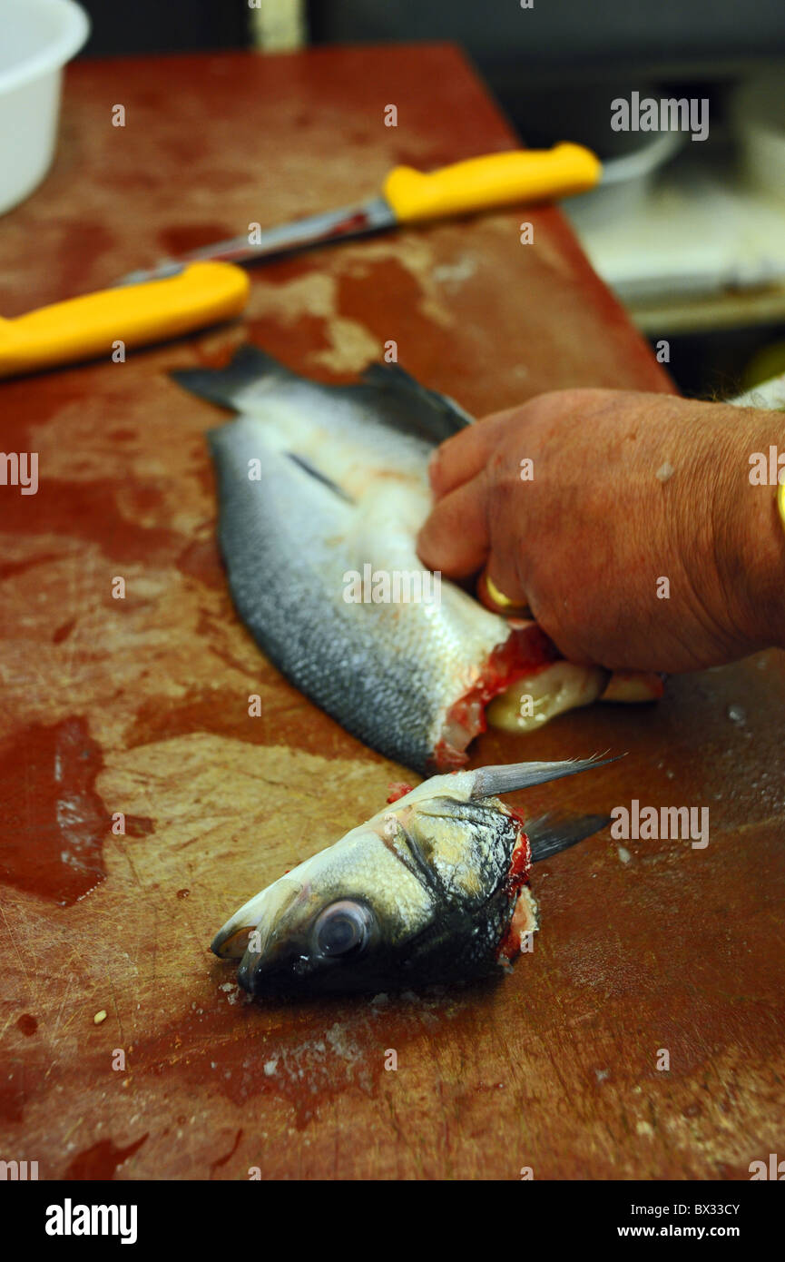 Bekannten Fischhändler Mike Watts Filetieren ein Seebarsch in seinem Geschäft in Brighton UK Stockfoto