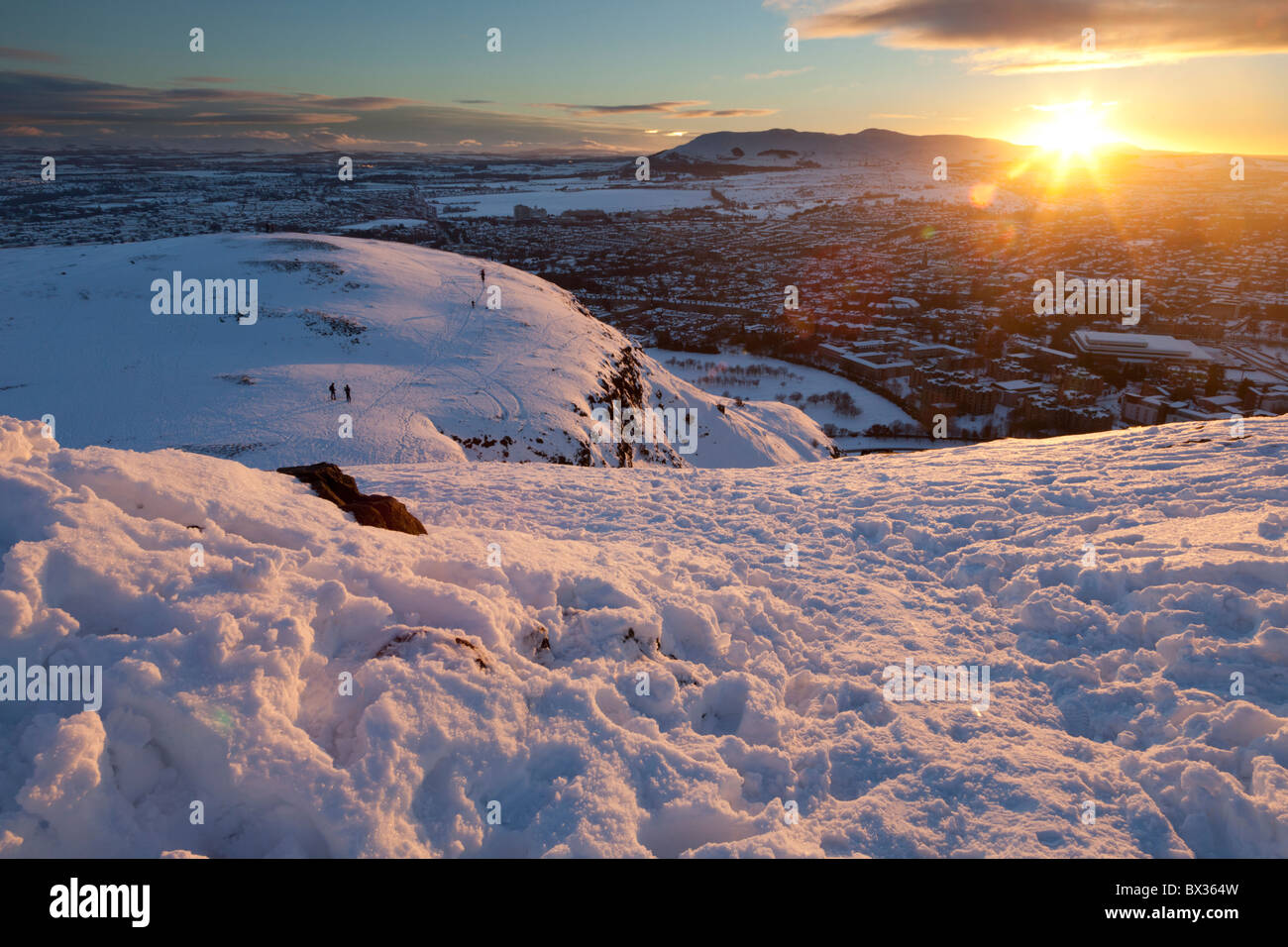 Sonnenuntergang über Edinburgh von der Spitze des verschneiten Arthurs Seat Stockfoto