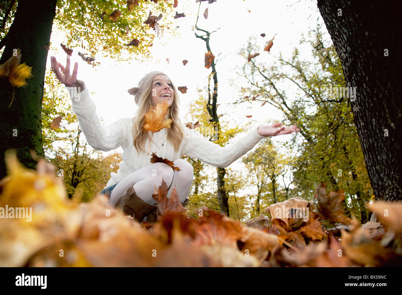 junges Mädchen im Park spielen mit Herbstlaub Stockfoto