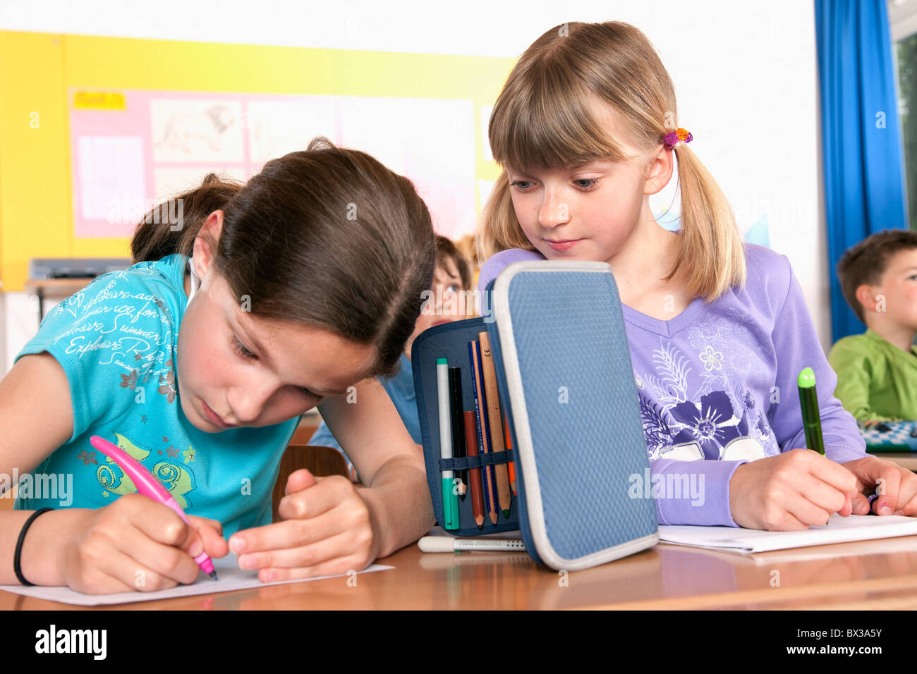 zwei junge Mädchen schreiben testen im Klassenzimmer eine versuchen zu betrügen Stockfoto
