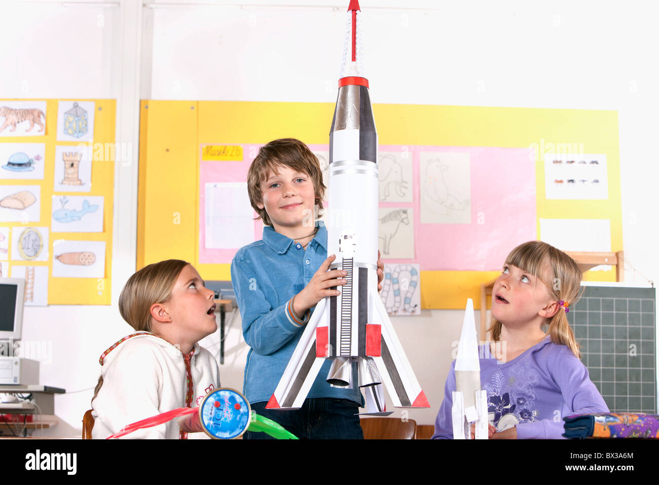 kleiner Junge im Klassenzimmer, Modell der Rakete Stockfoto