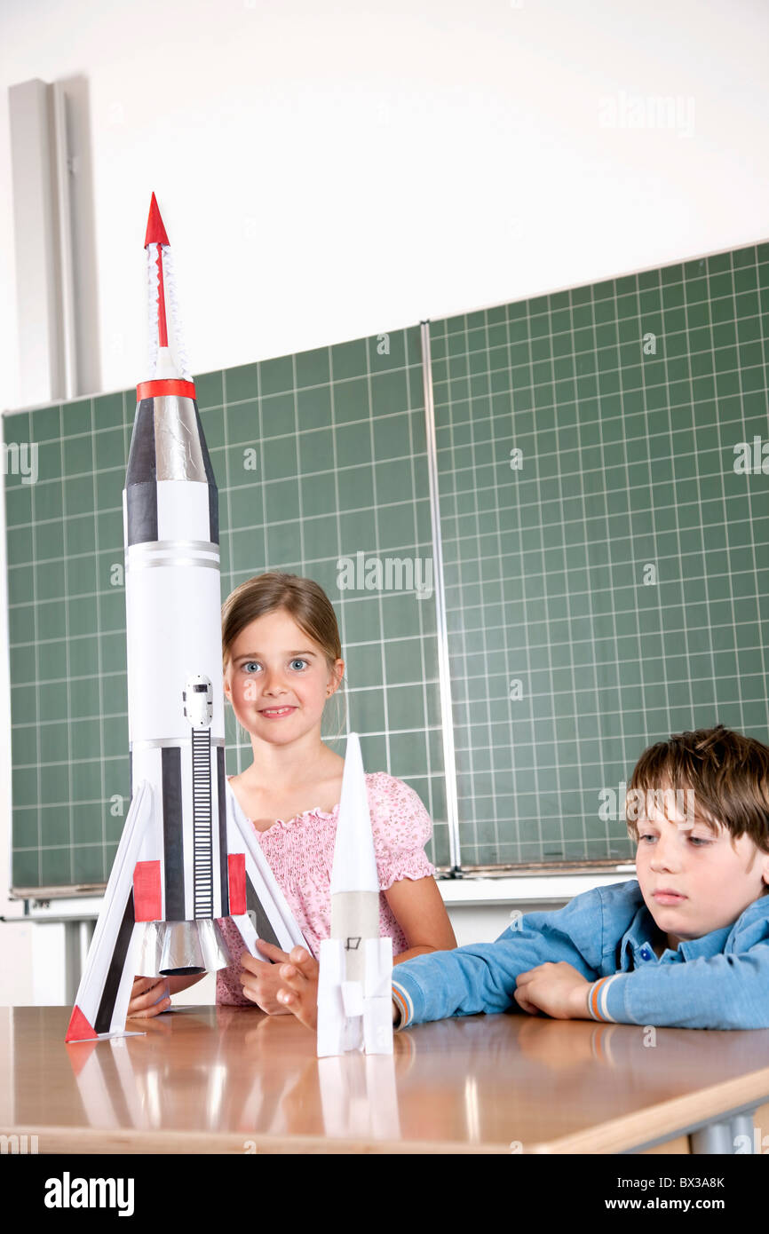 zwei Schüler im Klassenzimmer mit Modell der Rakete Stockfoto