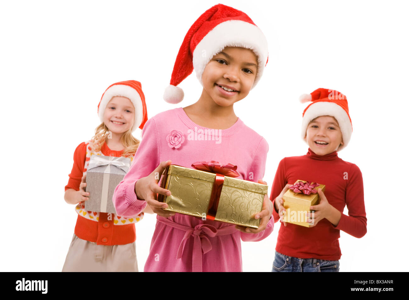 Glückliches Mädchen mit Blick in die Kamera mit ihren Freunden im Hintergrund Geschenkbox Stockfoto Glückliches Mädchen mit Blick in die Kamera mit ihren Freunden im Hintergrund Geschenkbox Stockfoto