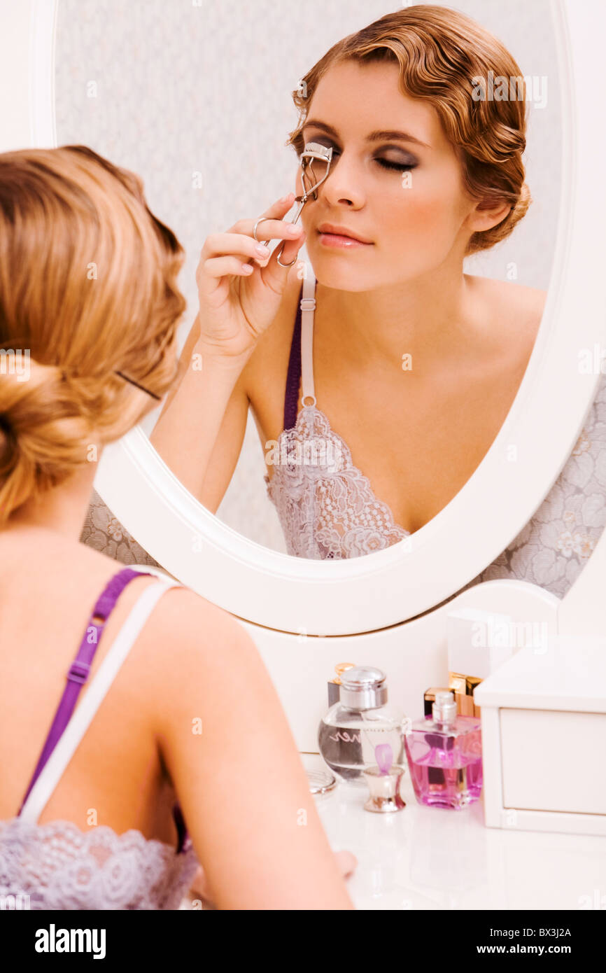 Bild der hübschen weiblichen Blick im Spiegel beim Eisstockschießen ihre Wimpern Stockfoto