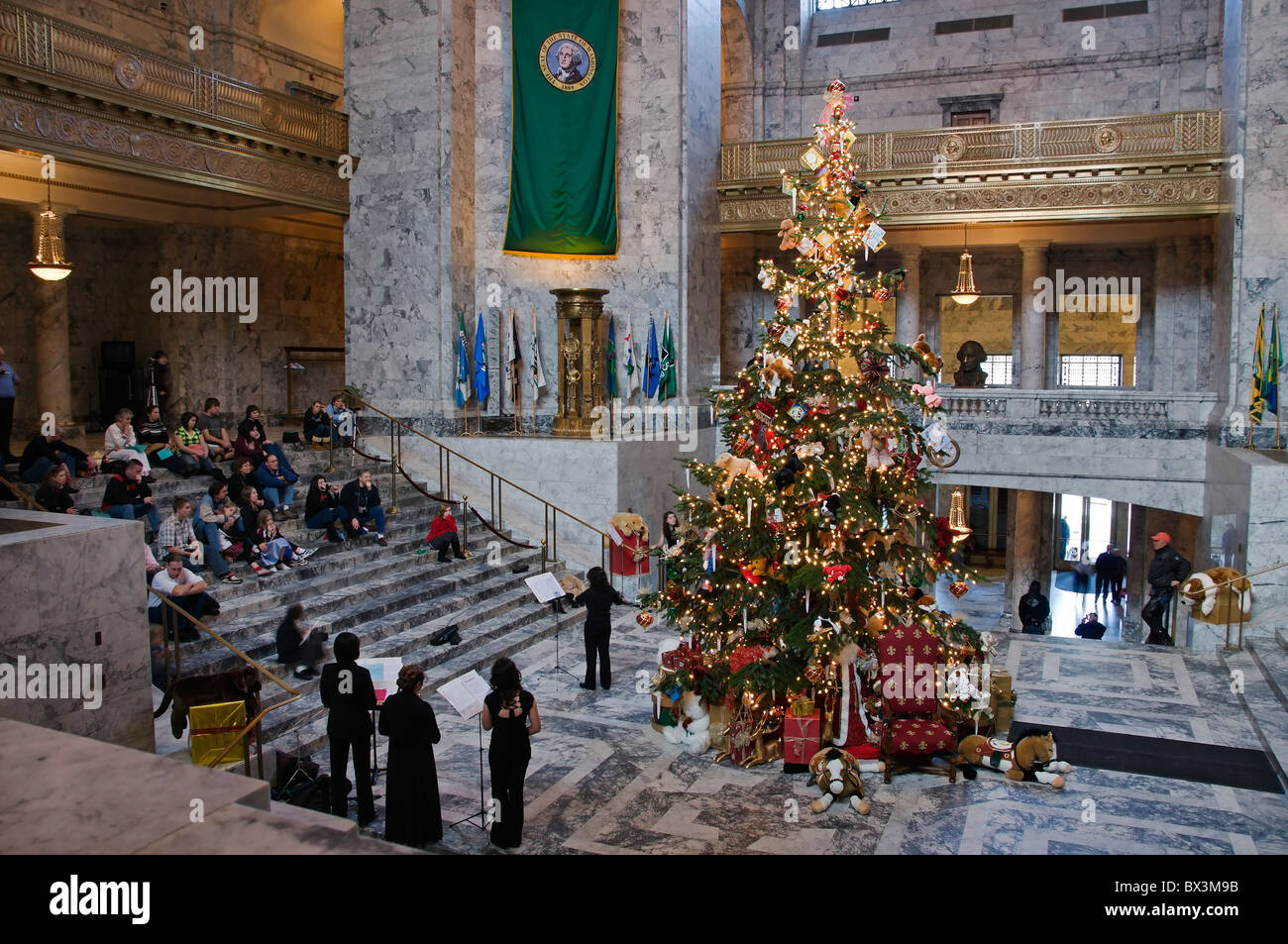 Musiker spielen vor dem Weihnachtsbaum in der Rotunde des Kapitols in Olympia, Washington. Stockfoto