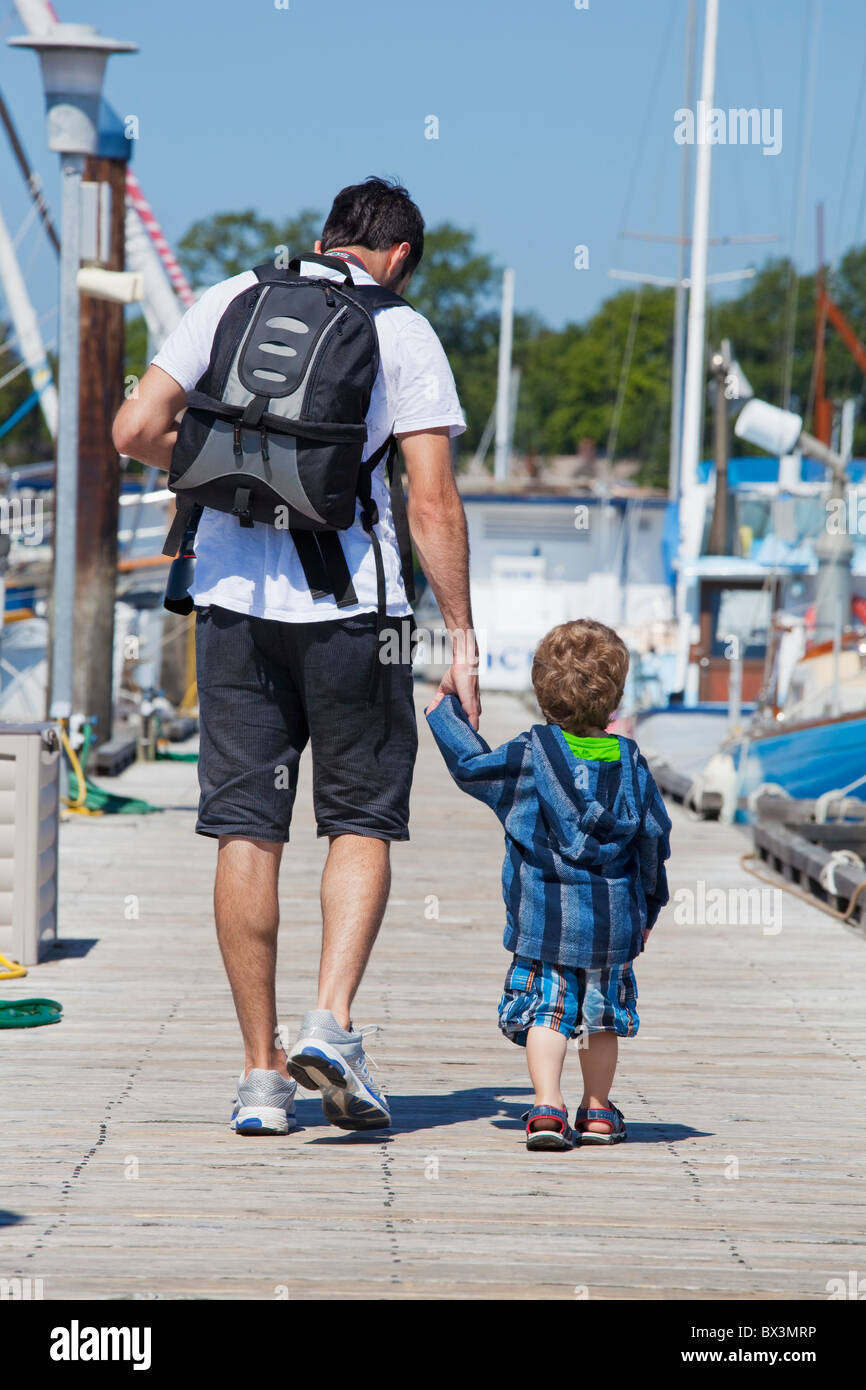 Ein Mann geht mit seinem kleinen Sohn auf einem Pier am Hafen; Langley, British Columbia, Kanada Stockfoto