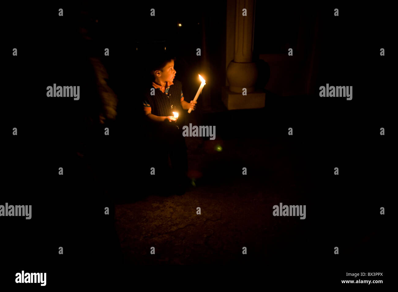 Ein Junge hält Kerzen auf dem Friedhof in San Gregorio Atlapulco, Xochimilco, Mexiko-Stadt Stockfoto