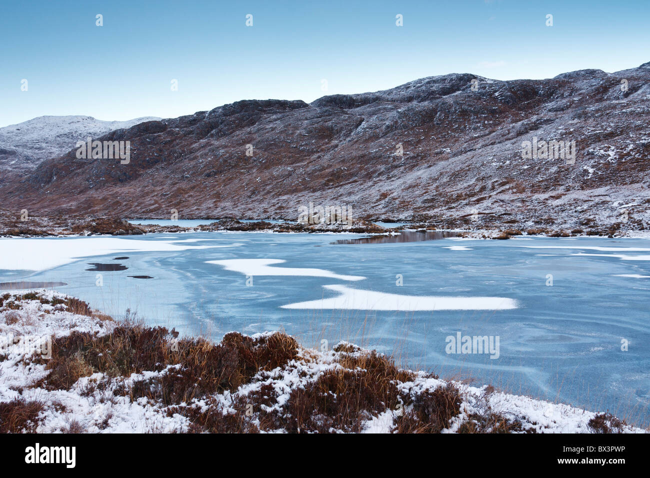 Eis-Muster, die in das gefrorene Wasser des Loch Lacasdail auf den westlichen Inseln Schottlands Stockfoto