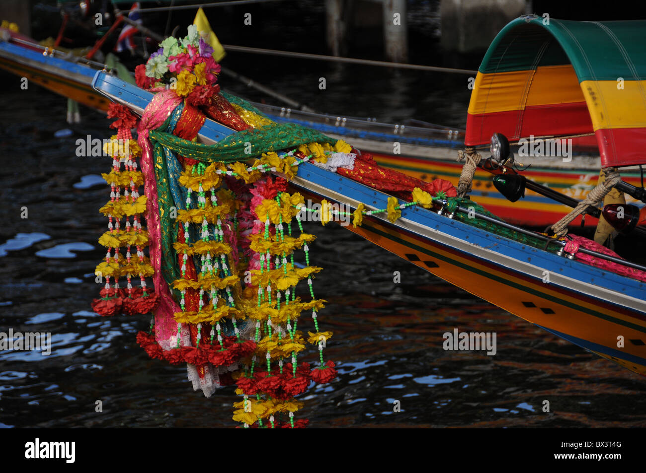 Blumengirlanden auf der Oberseite ein Longtail-Boot in Bangkok Stockfoto