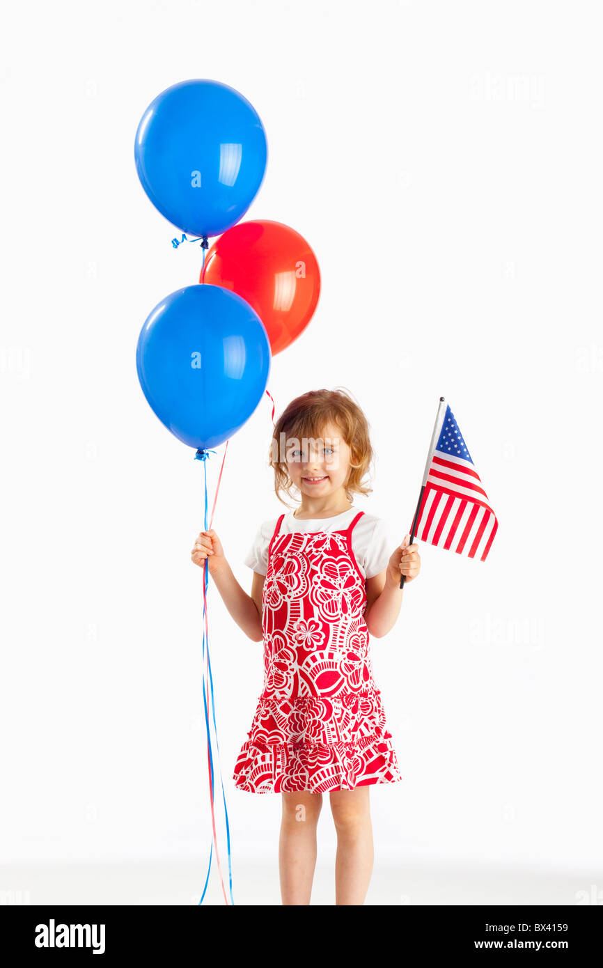 Ein Mädchen mit roten und blauen Luftballons und eine amerikanische Flagge Stockfoto