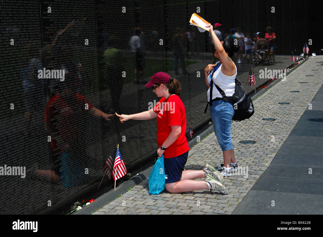 Besucher auf der Suche nach Namen von Verwandten und Freunden in der Name-Panels, Vietnam Veterans Memorial Wall, Washington, D.C., USA Stockfoto