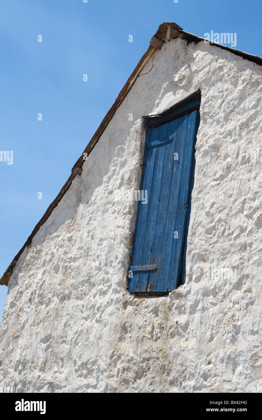 Altes Bauernhaus-Stil mit einer blauen Tür vor blauem Himmel Stockfoto