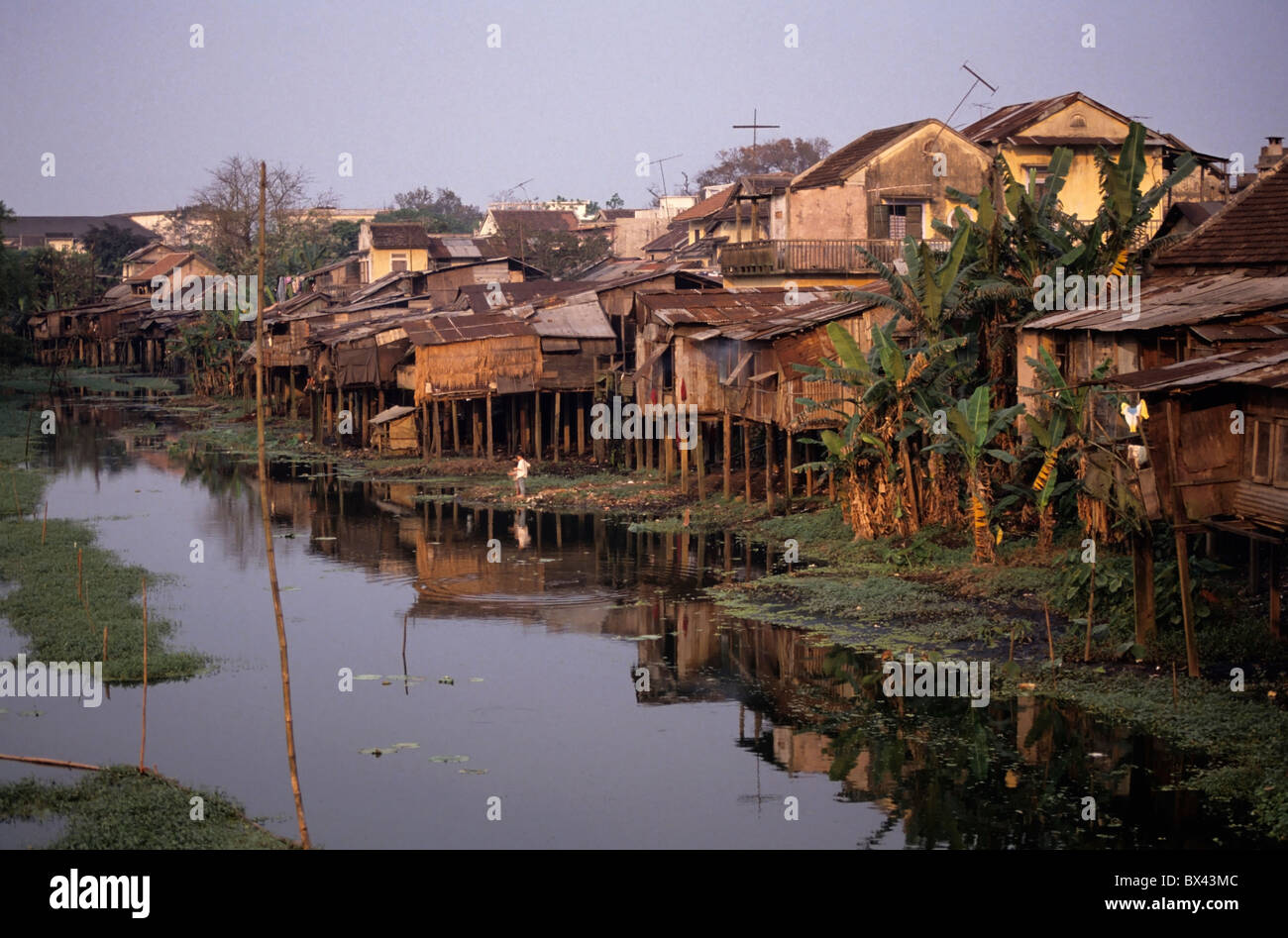 Häuser auf Stelzen an einem Fluss, Vietnam - in der Abenddämmerung. Stockfoto