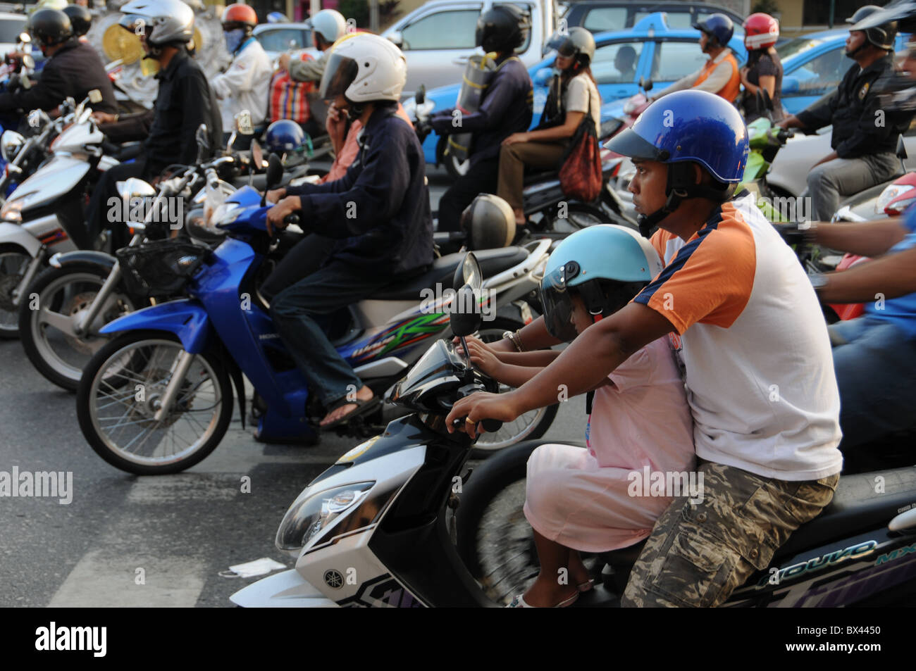 Scooter-Fahrer an einer Ampel in Bangkok warten Stockfoto