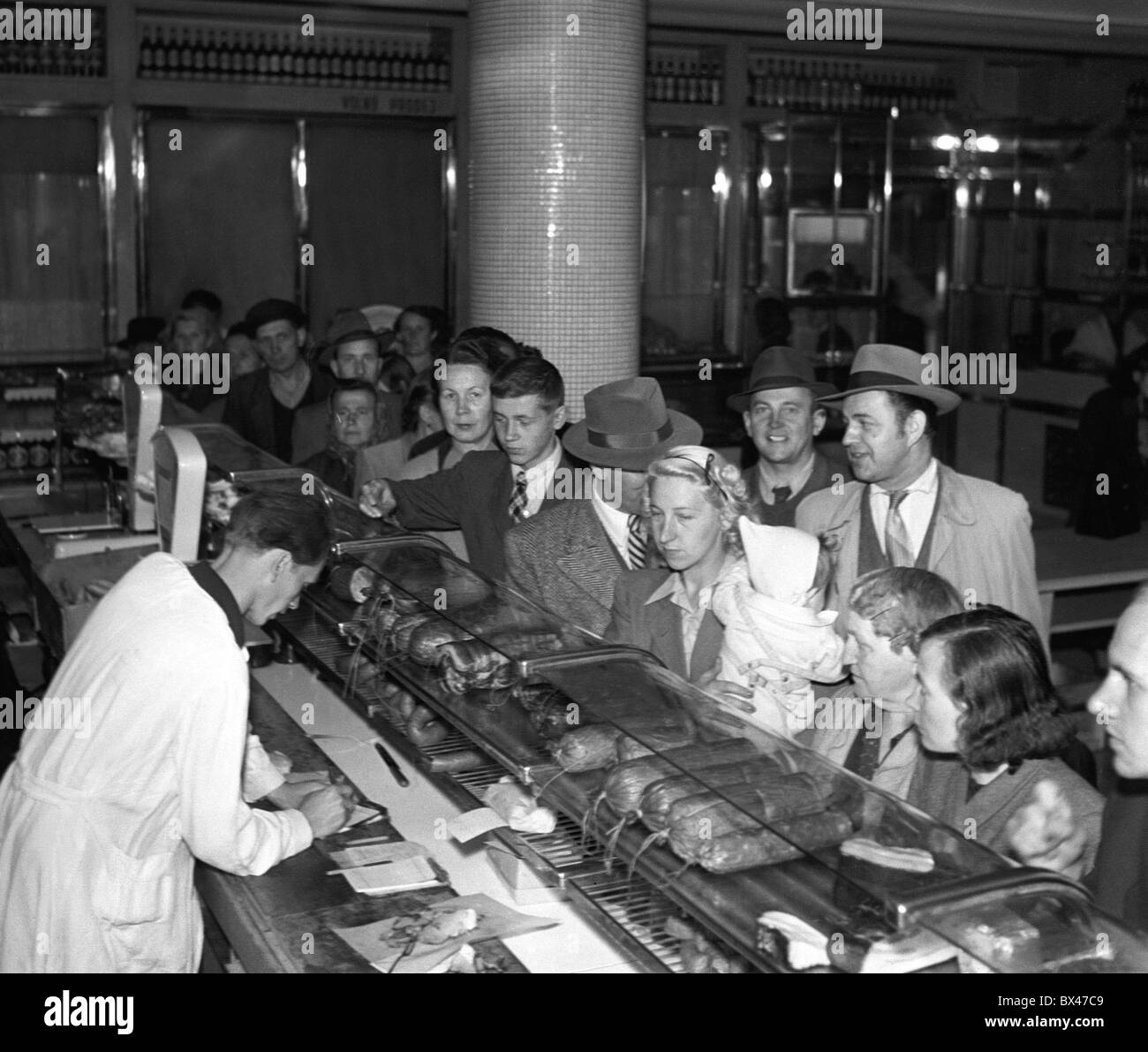 Tschechoslowakei - Prag 1949.  Menschen warten in der Schlange an der Reihe, Fleisch und Wurstwaren zu kaufen. Obwohl die Kommunisten erwähnen Stockfoto