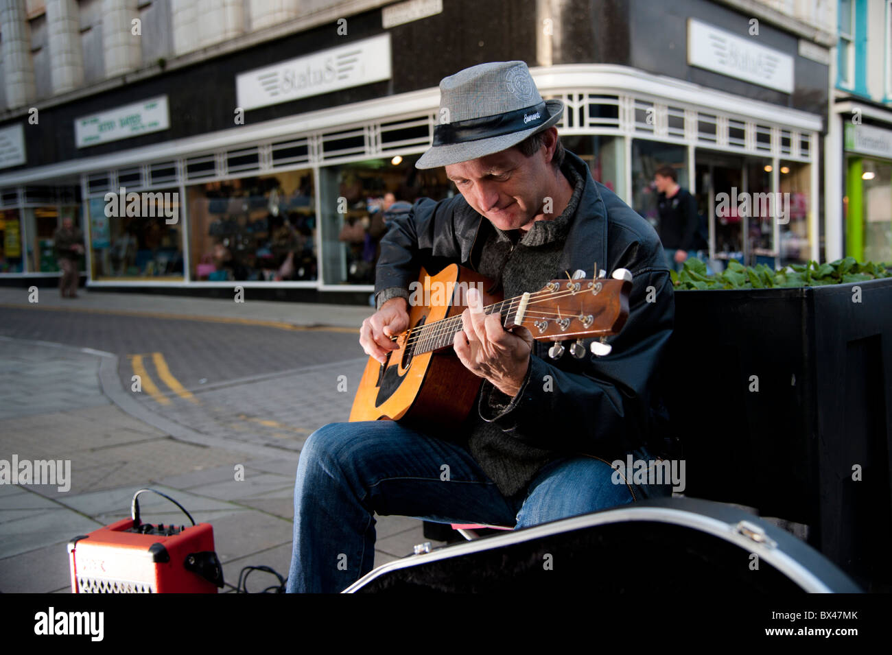Ein Mann Straßenmusik Gitarre spielen auf der Straße, Aberystwyth Wales UK Stockfoto