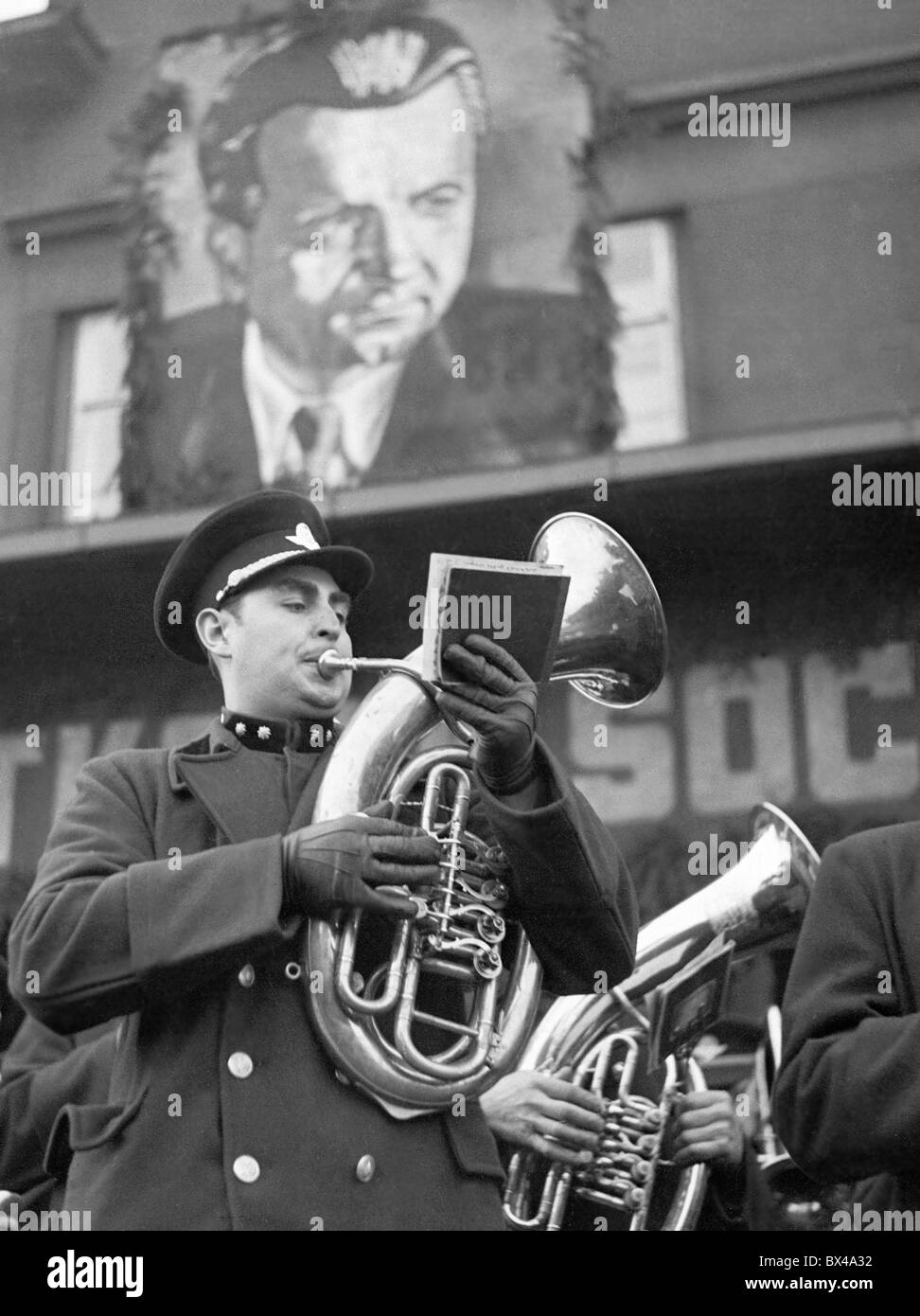 Tschechoslowakei - Prag 1949. Band spielt Volksmusik und riesige Klement Gottwald Portrait hängt vom Gebäude während der Stockfoto