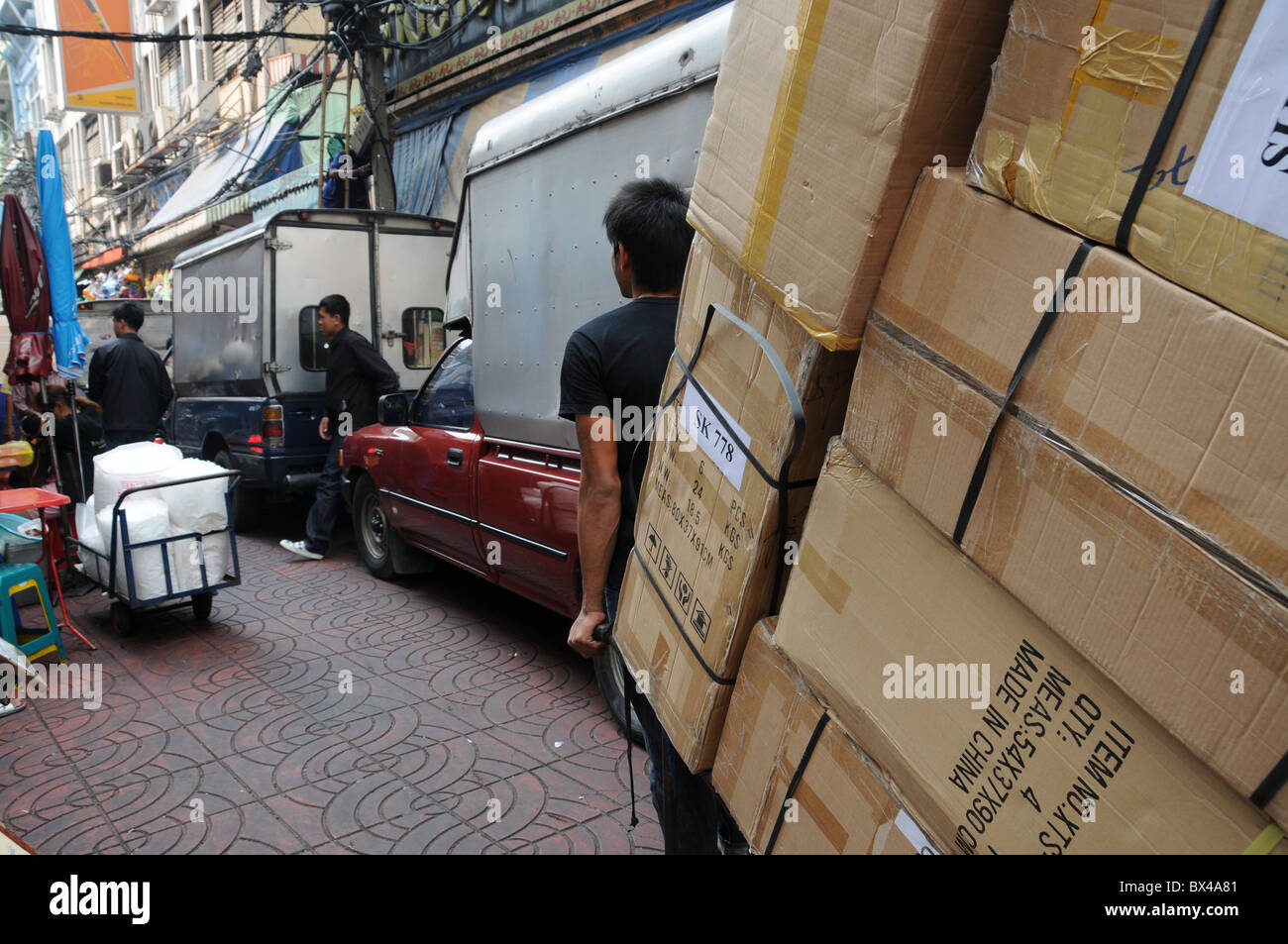 Man transportiert Kisten mit einer Sackkarre in Chinatown Bangok Stockfoto