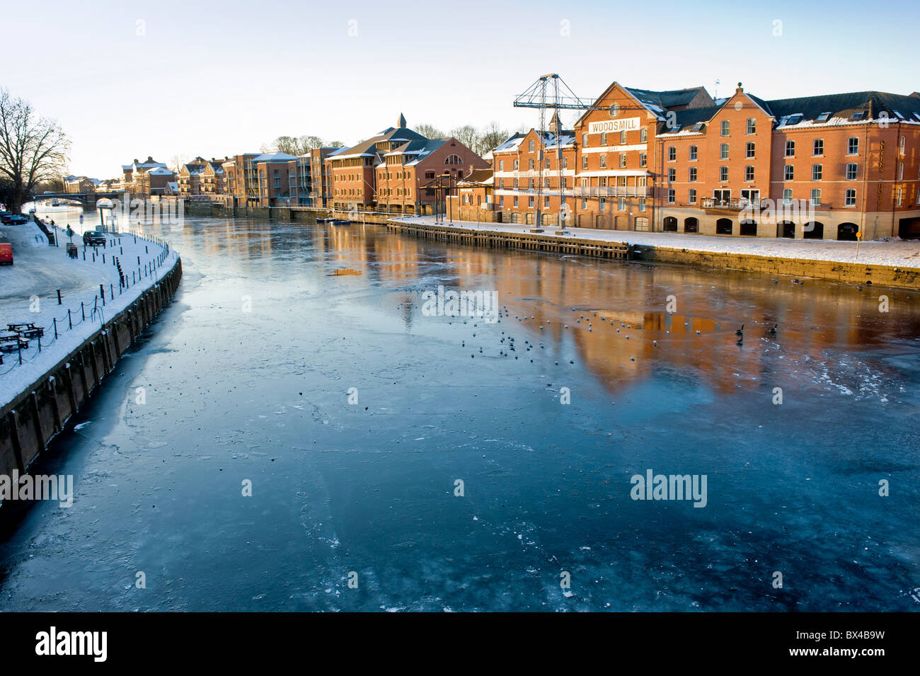 Woodsmill Gebäude auf Queen's Staith rechts vom gefrorenen Fluss Ouse, mit King's Staith links. Stockfoto