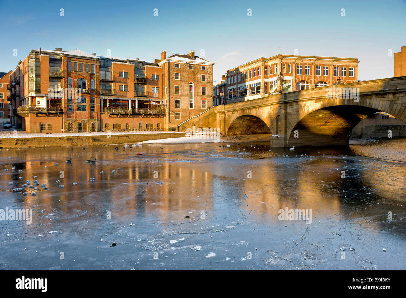 Riverside Buildings on Queen's Staith in York mit der Ouse Bridge, die einen gefrorenen Fluss Ouse überquert. Stockfoto