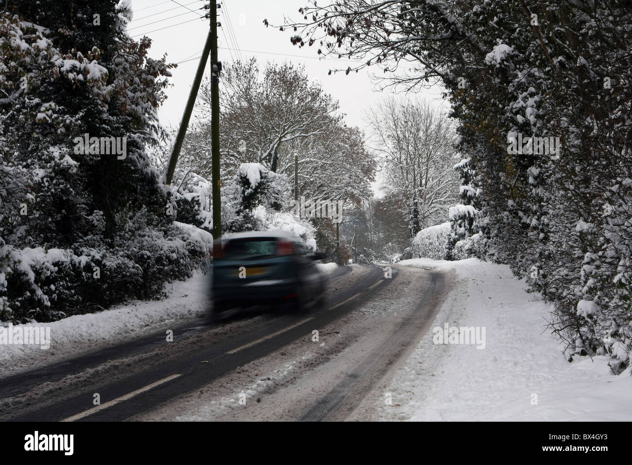 Ein Auto fahren auf eisigen Straßen bei shot-peening Viertel in The Weald of Kent, England Stockfoto