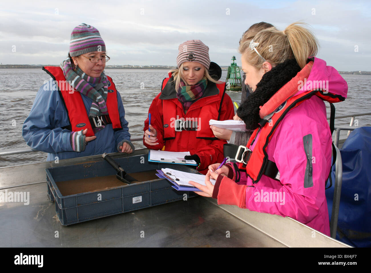 Studenten im Grundstudium Dimensionierung Sedimentproben auf den Fluss Mersey, Liverpool, UK Stockfoto