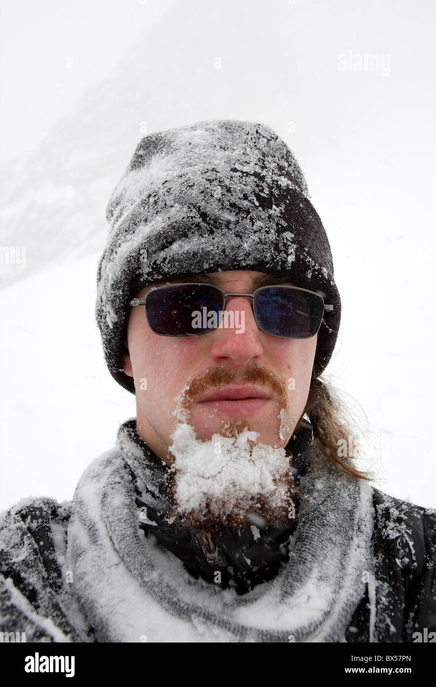 Porträt eines bärtigen Mannes Covers von Schnee in einem Schneesturm Stockfoto