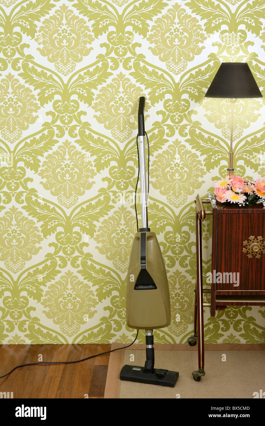 Retro-Staubsauger Vintage 60er Jahre Zimmer grüne Tapete Stockfoto