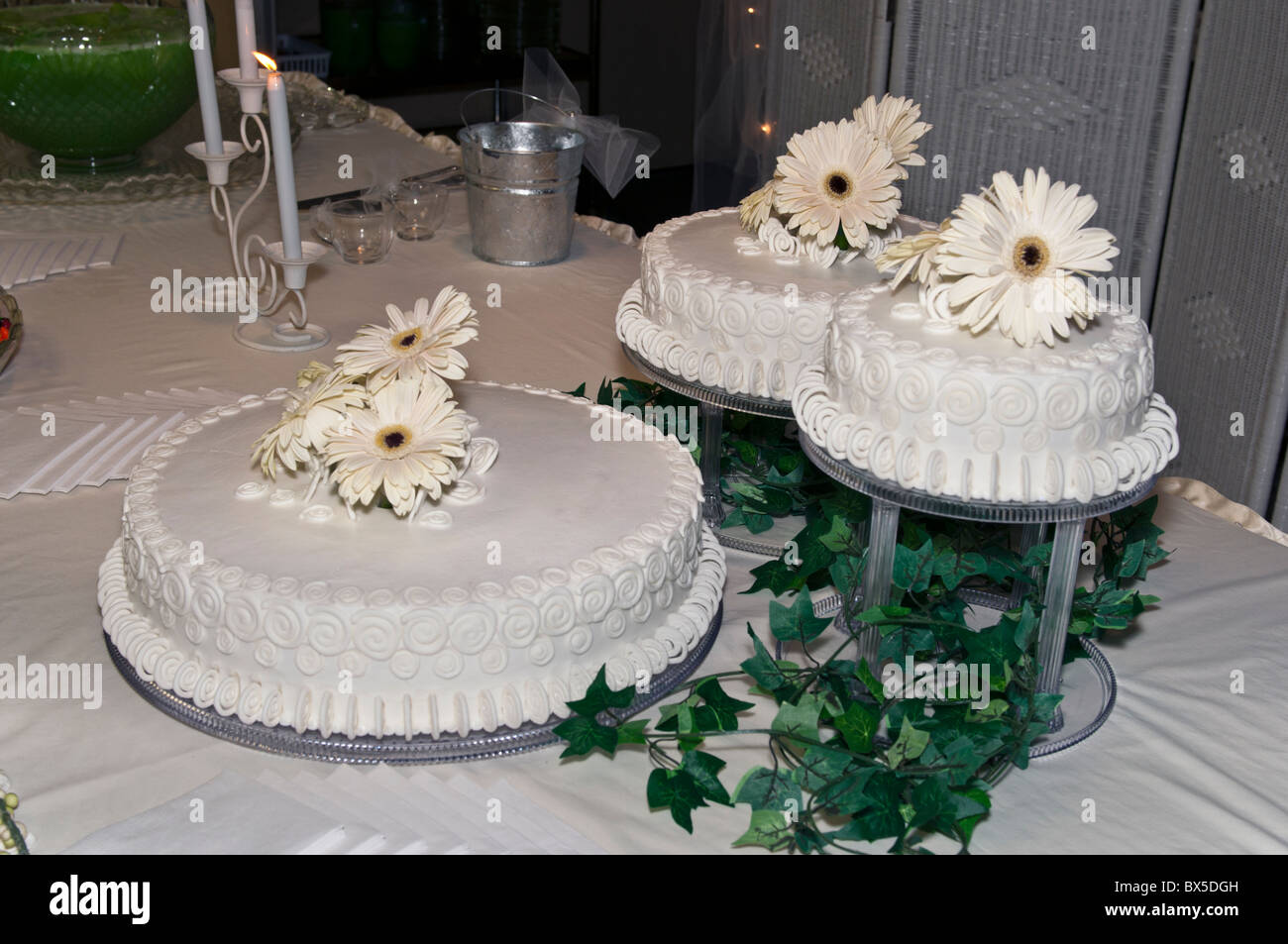 Drei weisse Hochzeit Kuchen mit weißen Blumen Dekoration und viel Grün. USA. Stockfoto