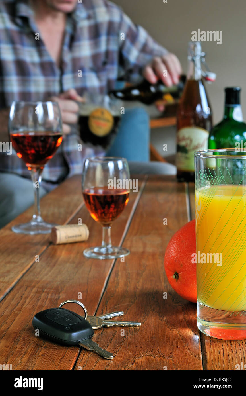 Autoschlüssel, betrunkener Mann Gießen Bier, Fruchtsäfte und alkoholische Getränke am Tisch zu veranschaulichen verantwortlich zu fahren Stockfoto