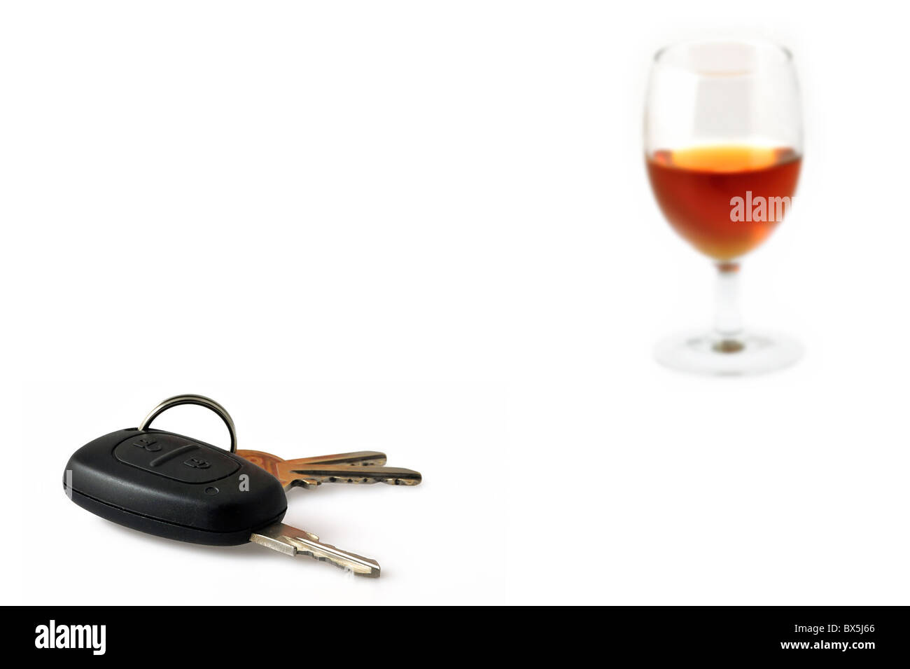 Autoschlüssel und Glas als konzeptionelle Themen veranschaulichen unverantwortlich fahren mit Alkohol gefüllt Stockfoto