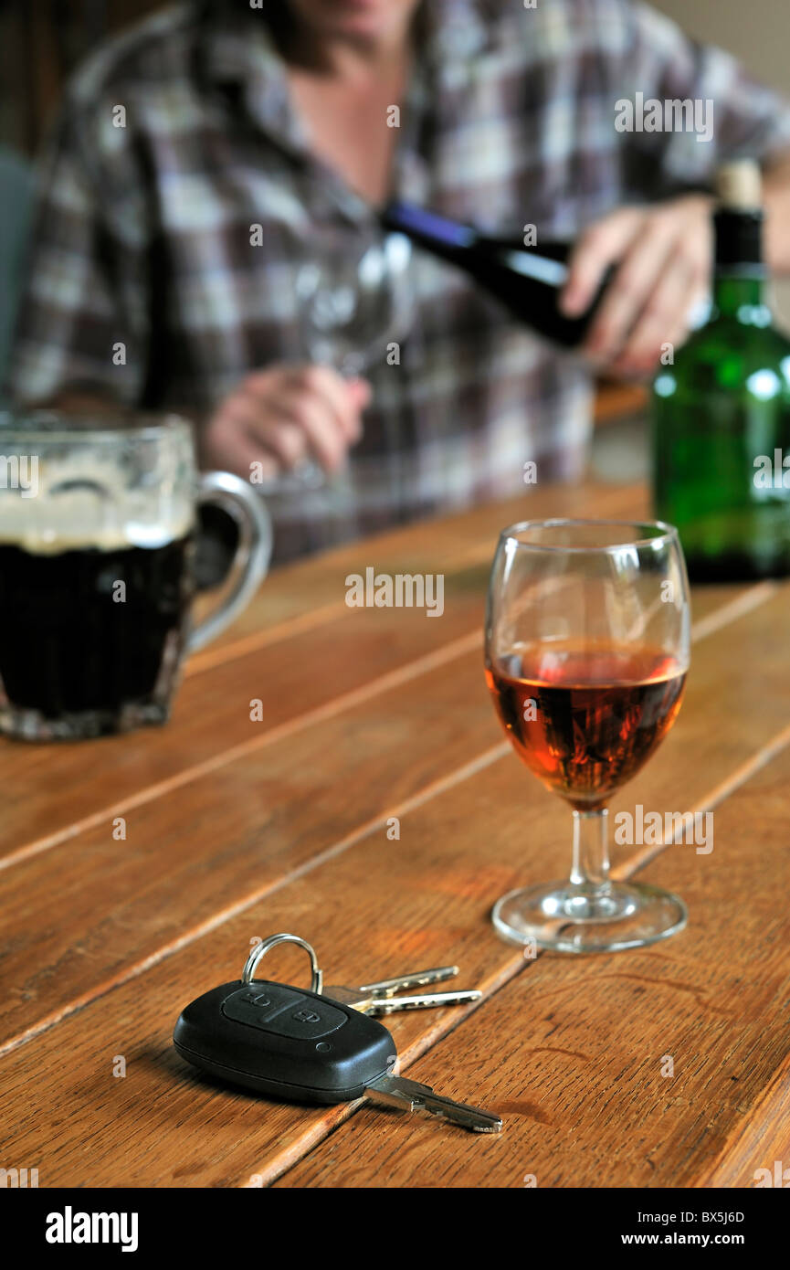 Autoschlüssel, betrunkener Mann gießt Wein und alkoholische Getränke auf Tabelle veranschaulichen unverantwortlich fahren Stockfoto