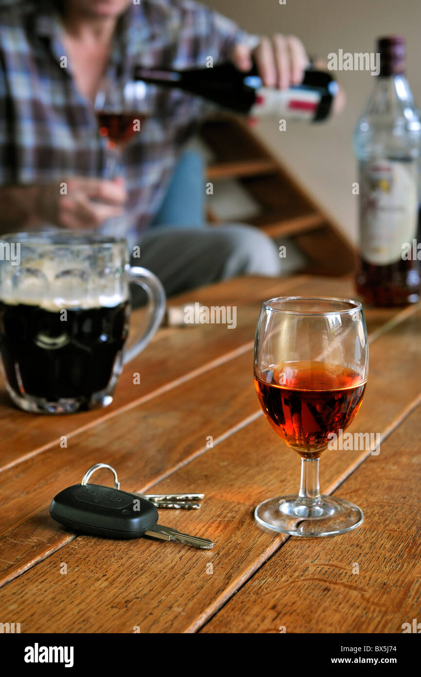 Autoschlüssel, betrunkener Mann gießt Wein und alkoholische Getränke auf Tabelle veranschaulichen unverantwortlich fahren Stockfoto