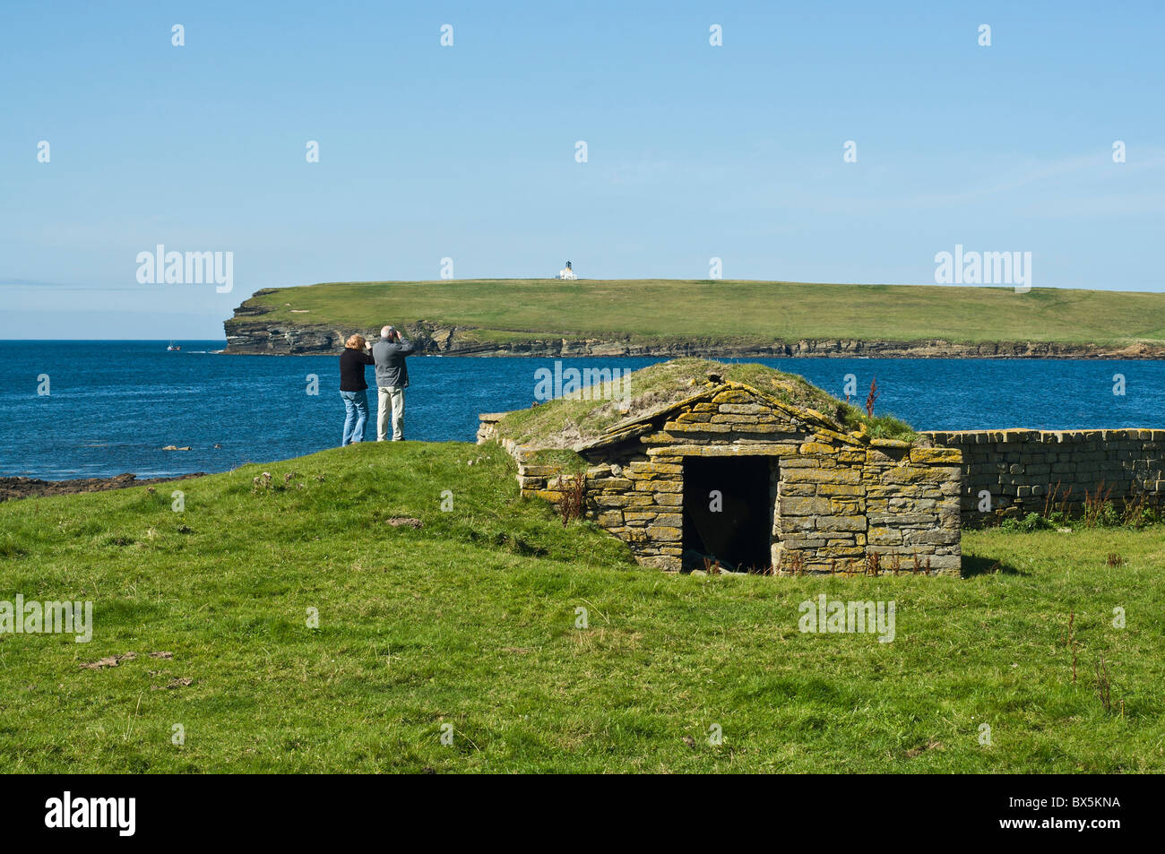 dh Brough of Birsay BIRSAY ORKNEY paar touristische Besucher Seevögeln Bucht von Birsay Fernglas betrachten Stockfoto