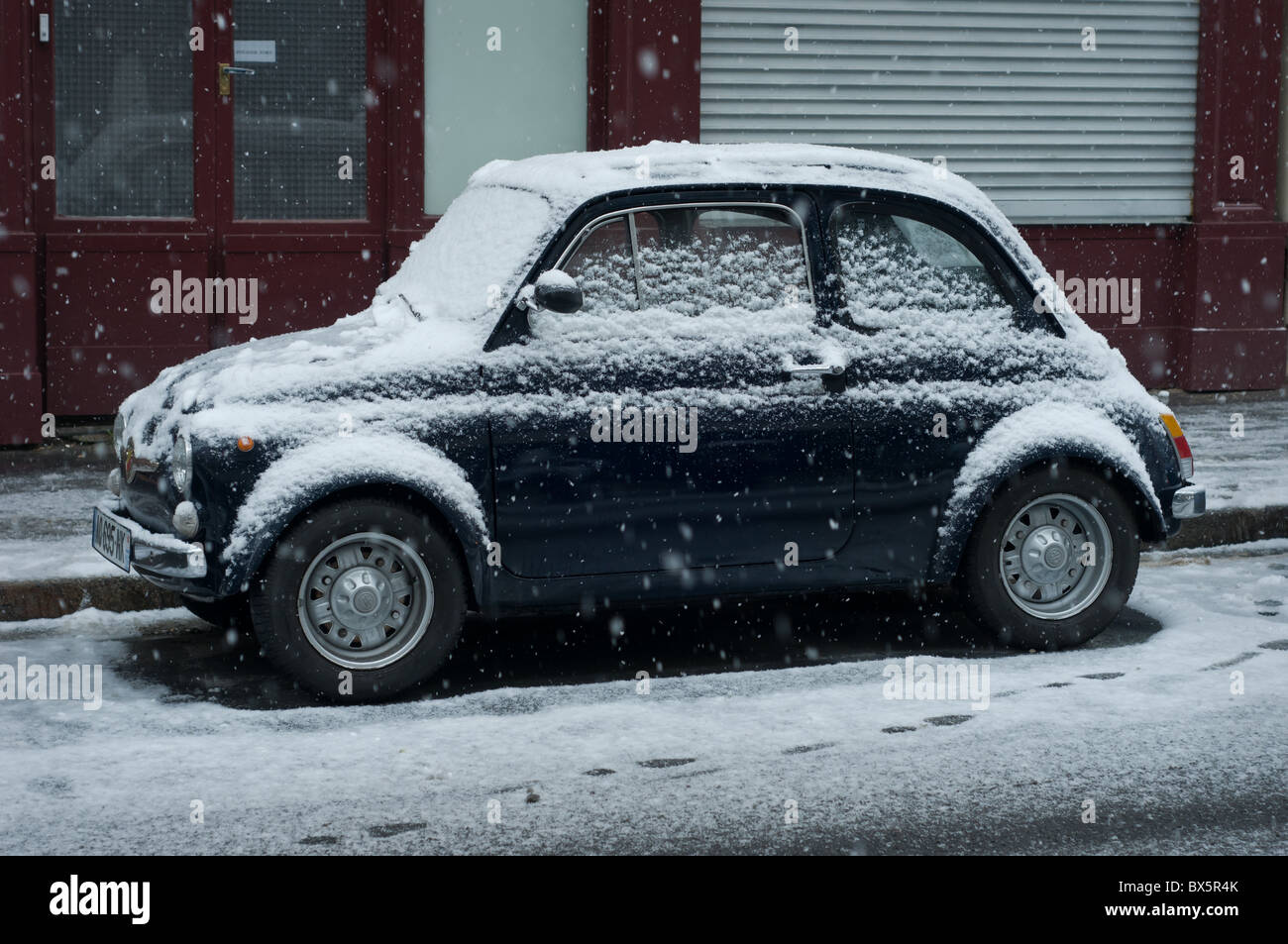 Fiat Kleinwagen bedeckt mit Schnee in einer Paris Straße. Stockfoto