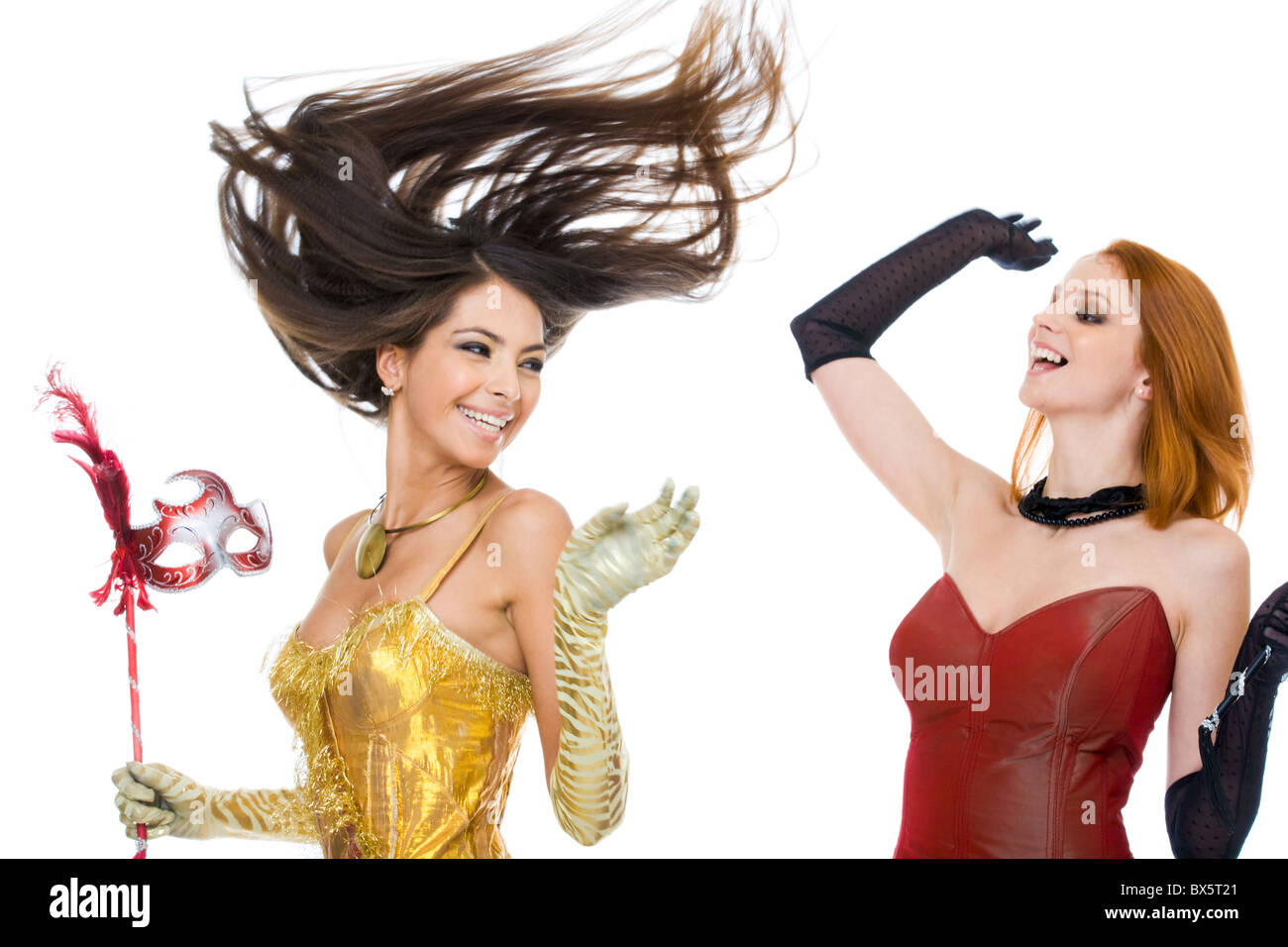 Foto von freudigen Schauspielerinnen in modische Kleider lachen über weißem Hintergrund Stockfoto