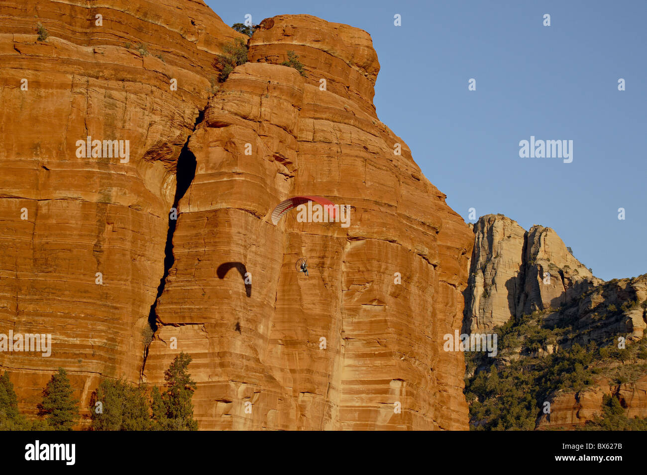 Ein Gleitschirm fliegt vorbei an einer roten Felsformation, Coconino National Forest, Arizona, Vereinigte Staaten von Amerika, Nordamerika Stockfoto