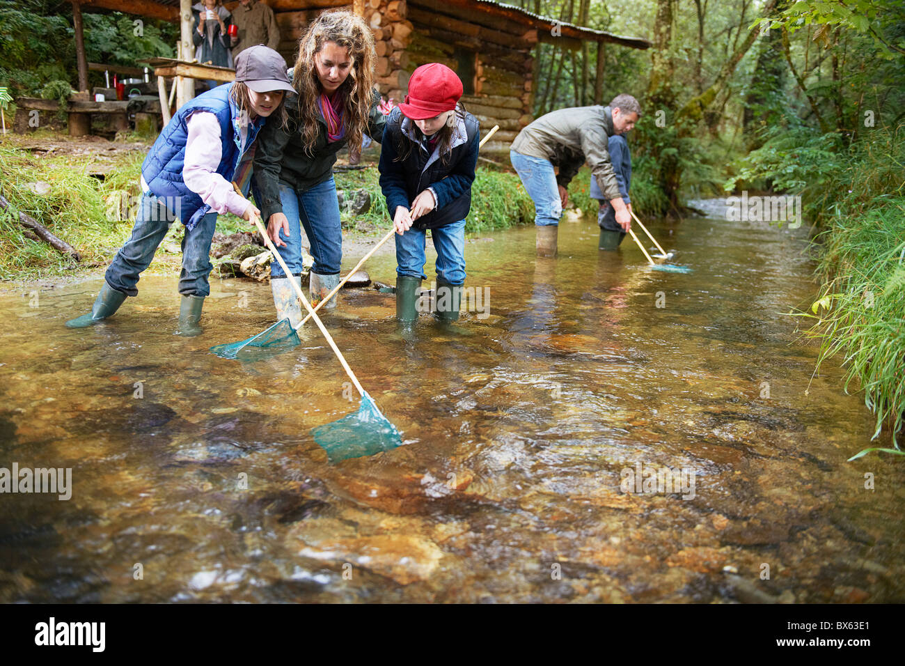 Familie Fischen mit Netzen in einem Fluss Stockfoto