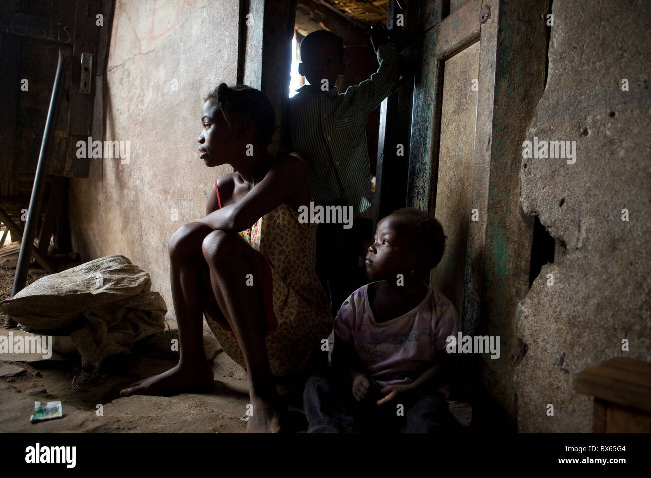 Kinder sitzen in der Tür ihrer Einzimmerwohnung in Monrovia, Liberia, Westafrika. Stockfoto