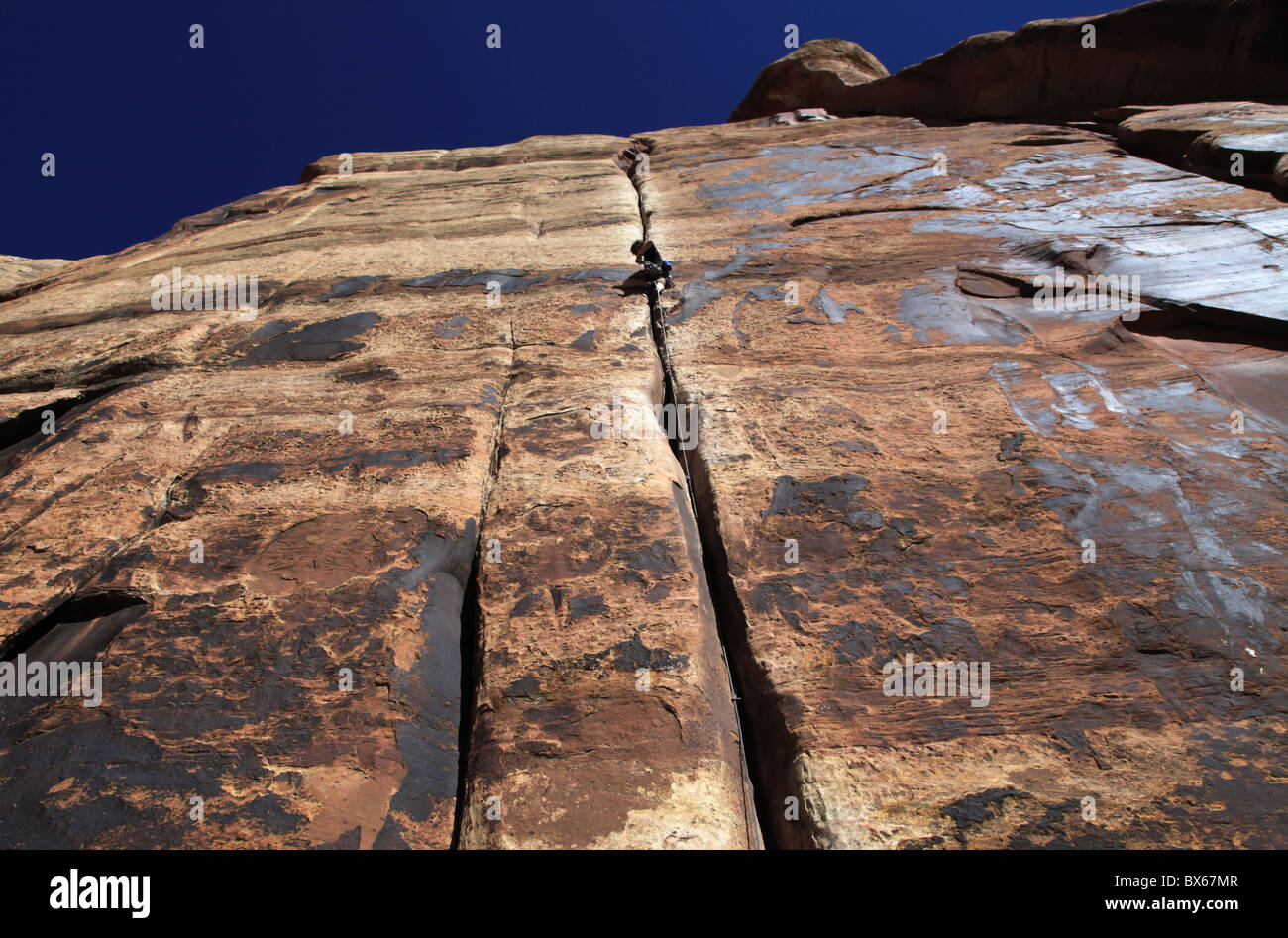 Ein Kletterer packt einen überhängenden Riss des Indian Creek im Canyonlands National Park, in der Nähe von Moab, Utah, USA Stockfoto