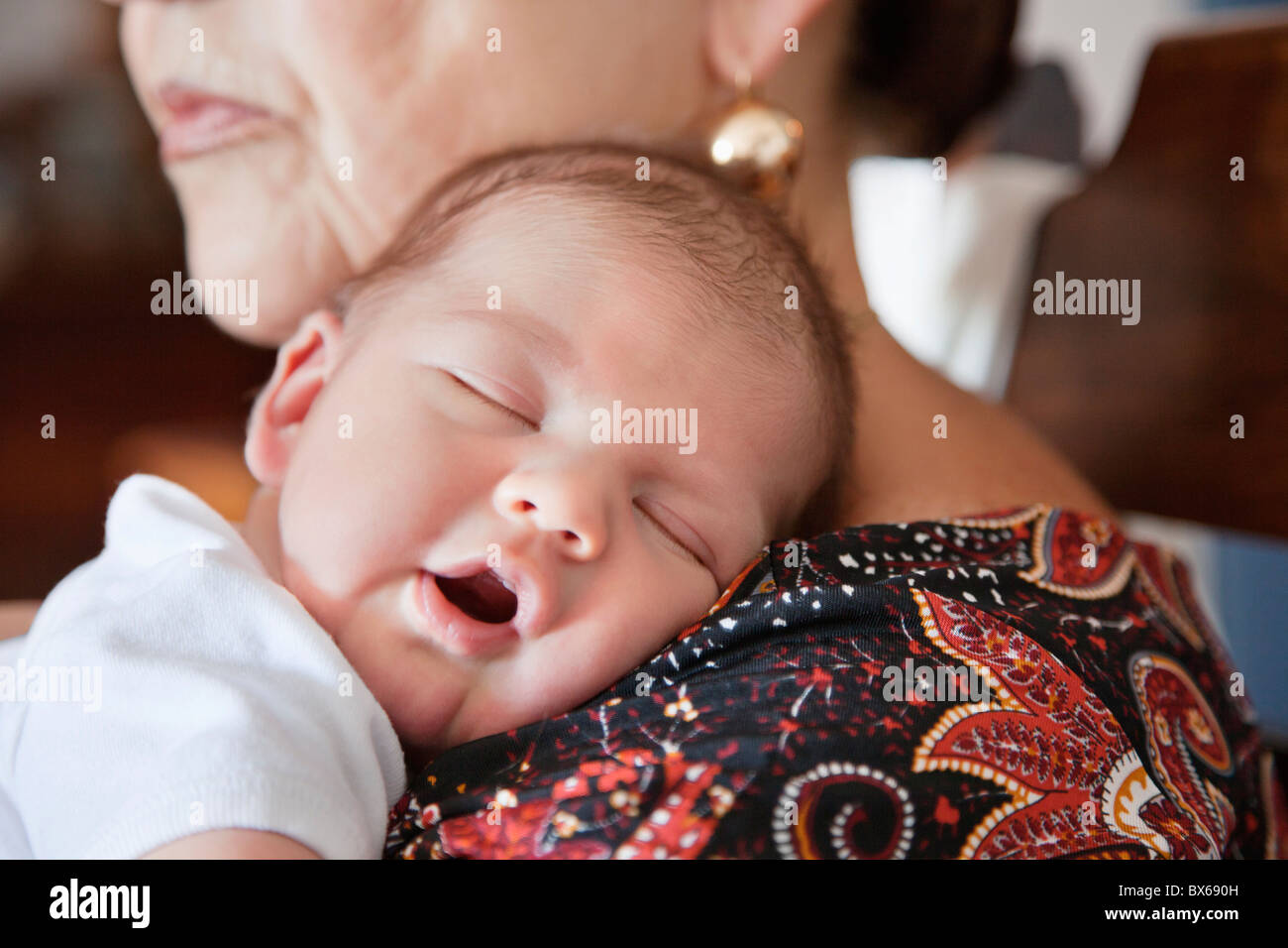 Baby schläft auf Großmütter Schulter Stockfoto