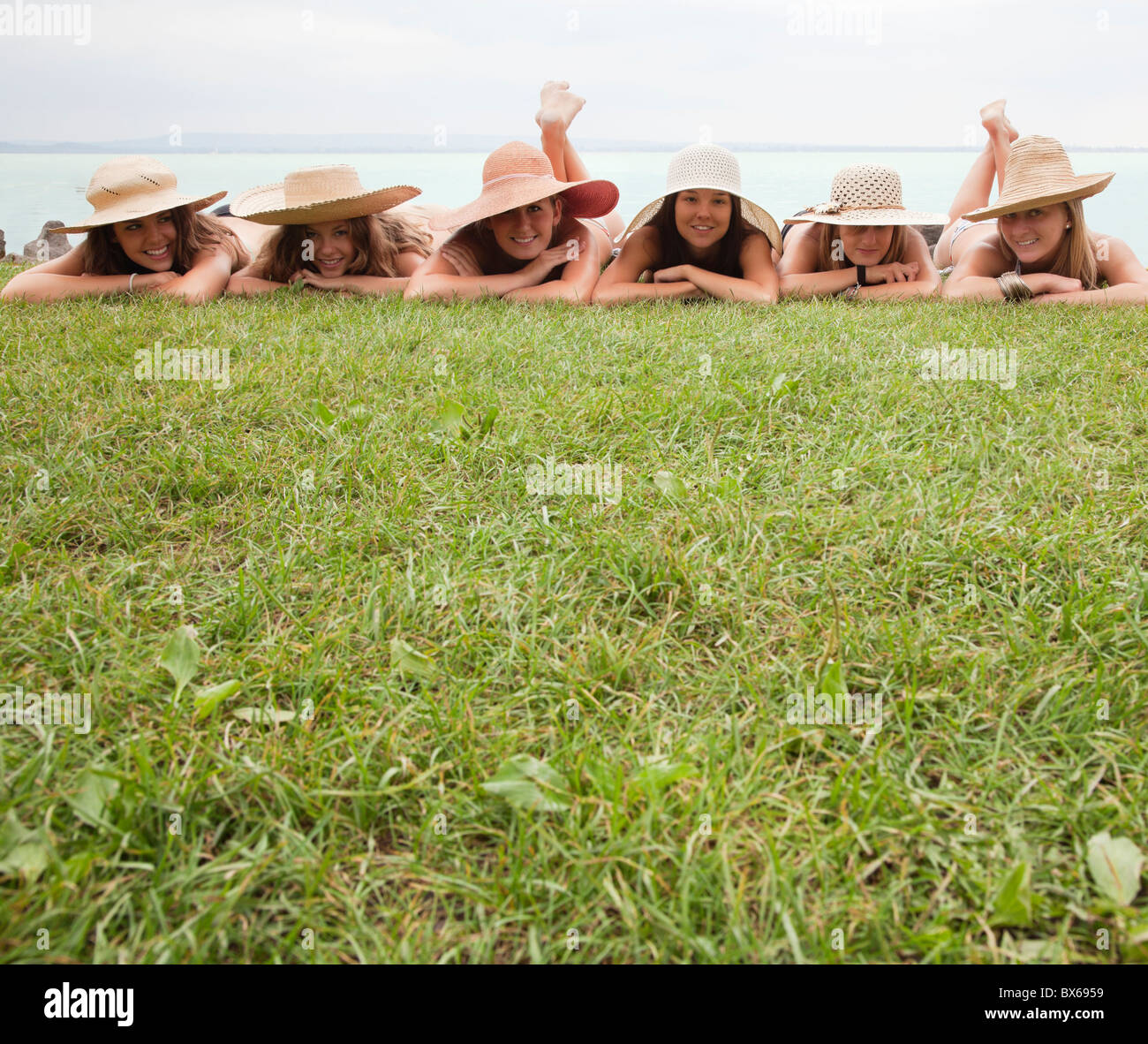 Frauen in Strohhüte liegen auf Rasen Stockfoto
