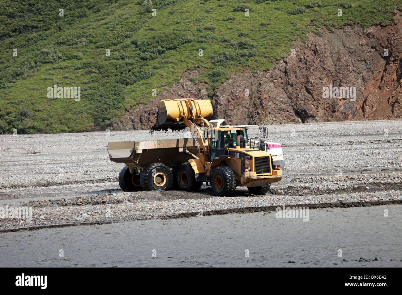 Ausrüstung, ein Lader, ein Muldenkipper mit Felsen zu füllen, während der Bauphase im Denali Nationalpark, Alaska, USA Stockfoto